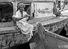 Ferryman  A ferryman counts his money while resting against another boat.  Taken on the Buriganga river in Dhaka, Bangladesh. : BW, Bangladesh