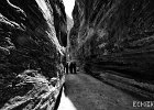 Through the Rocks  A group of women walking through the narrow passage ways leading through the rocks on the way to Petra. : BW, Jordan, Petra